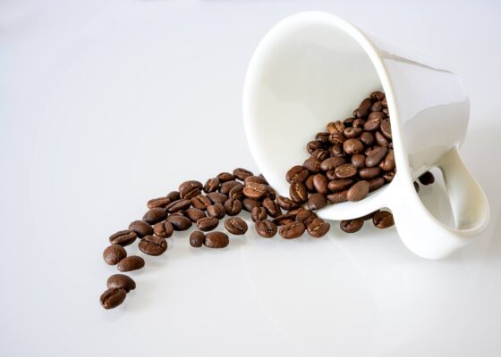 Coffee beans spilling from a coffee cup suggesting chaos 