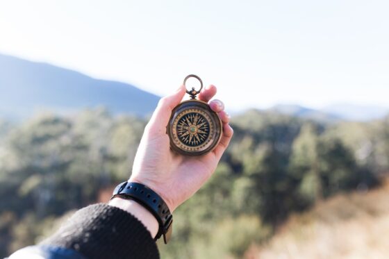 A hand holding a compass suggesting being guided by a moral compass